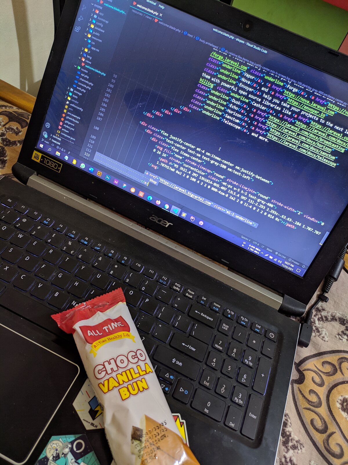 A packaged sweet bun on a keyboard in front of code.
