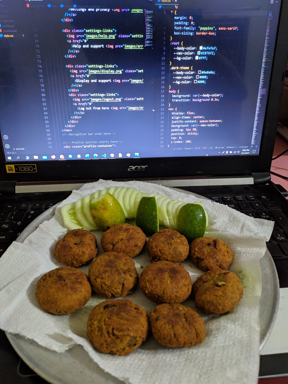 A plate of fried chops garnished with lime beside a laptop.