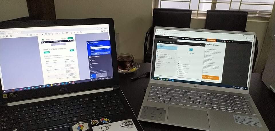 Two laptops set side by side on a desk, both showing work.