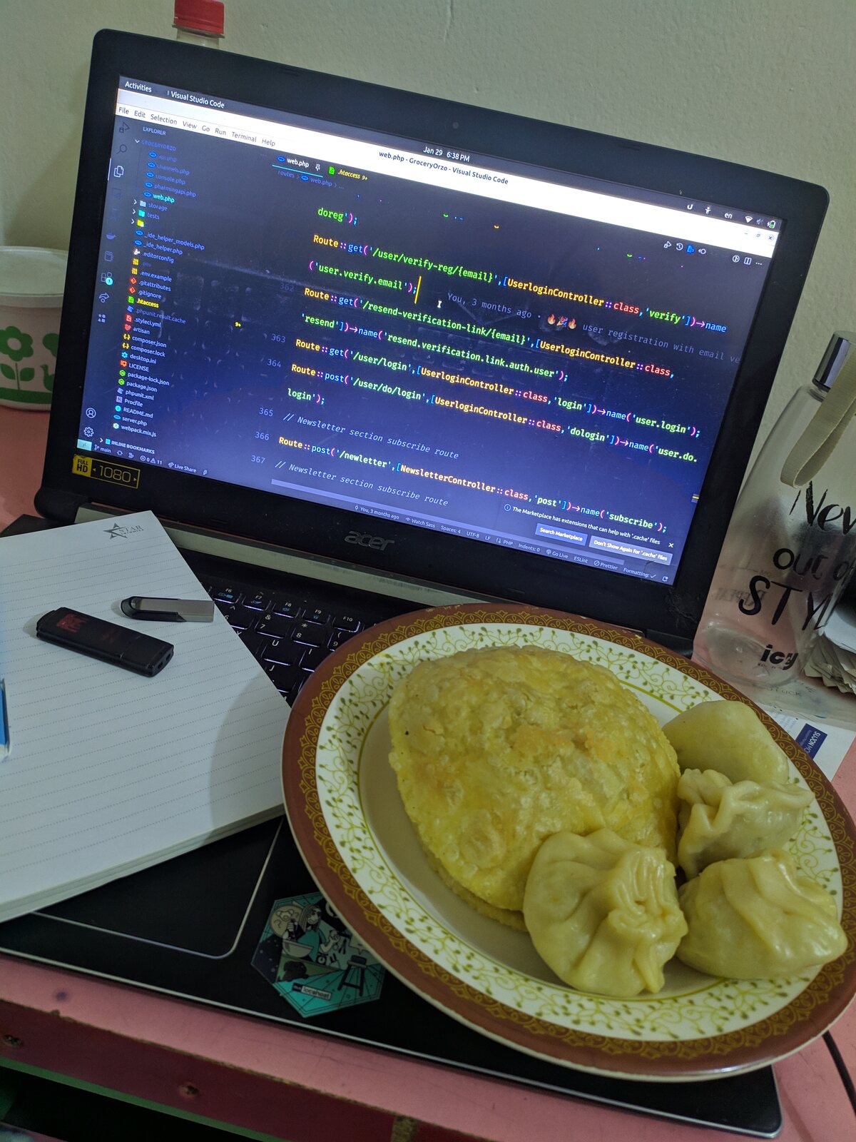 A hand peeling a banana in front of a laptop showing code.