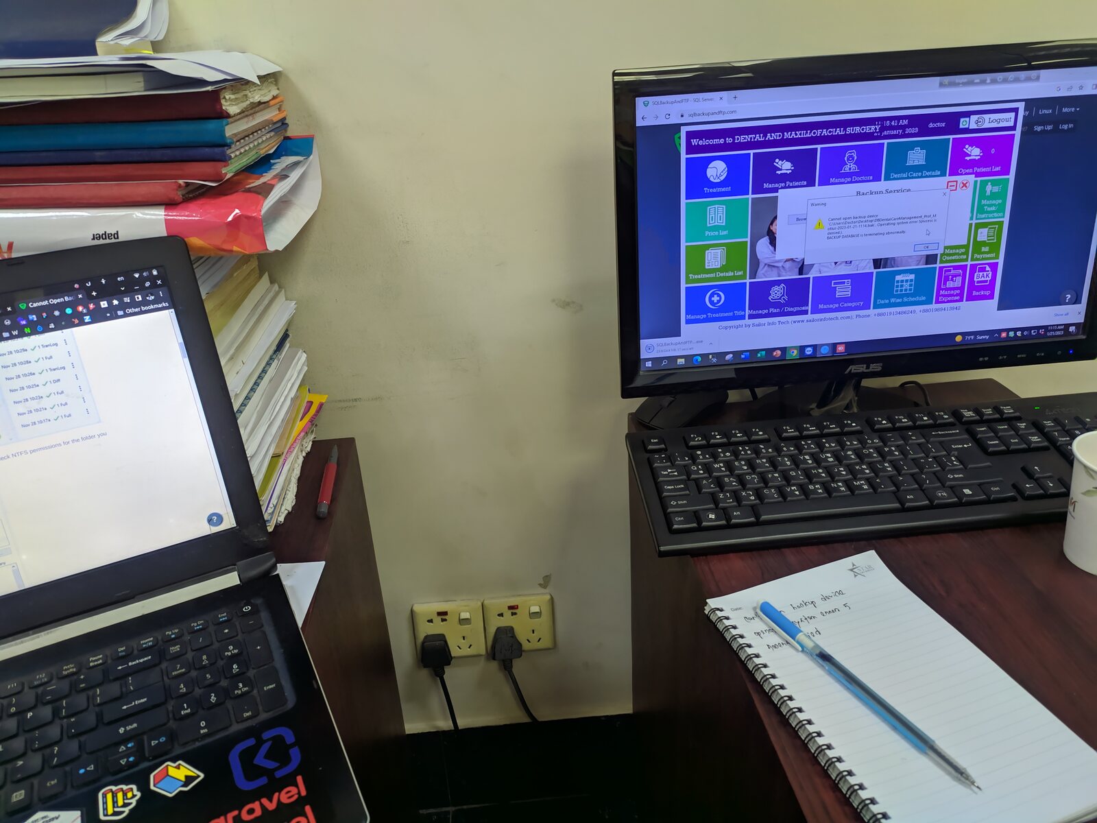 An open notebook and pen beside a laptop in daylight.