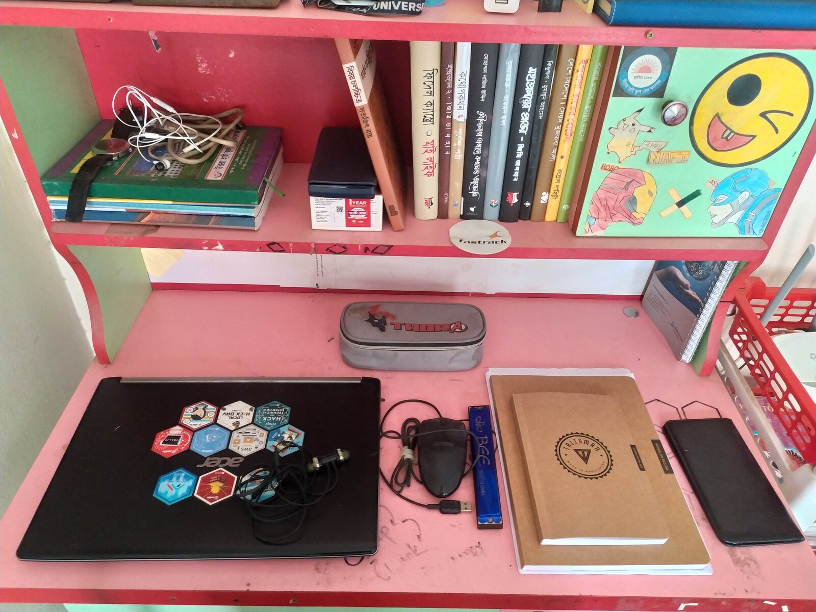 A compact shelf-desk with books above and a laptop below.