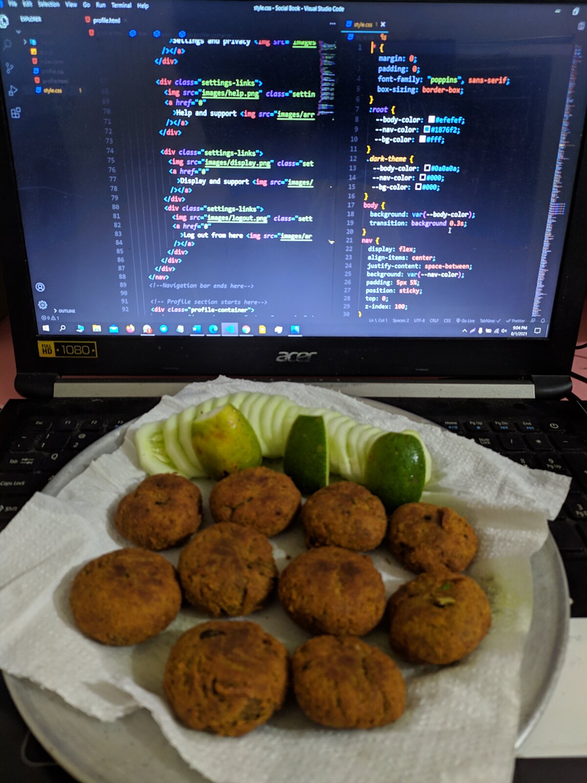A plate of spring rolls with red sauce in front of a laptop.
