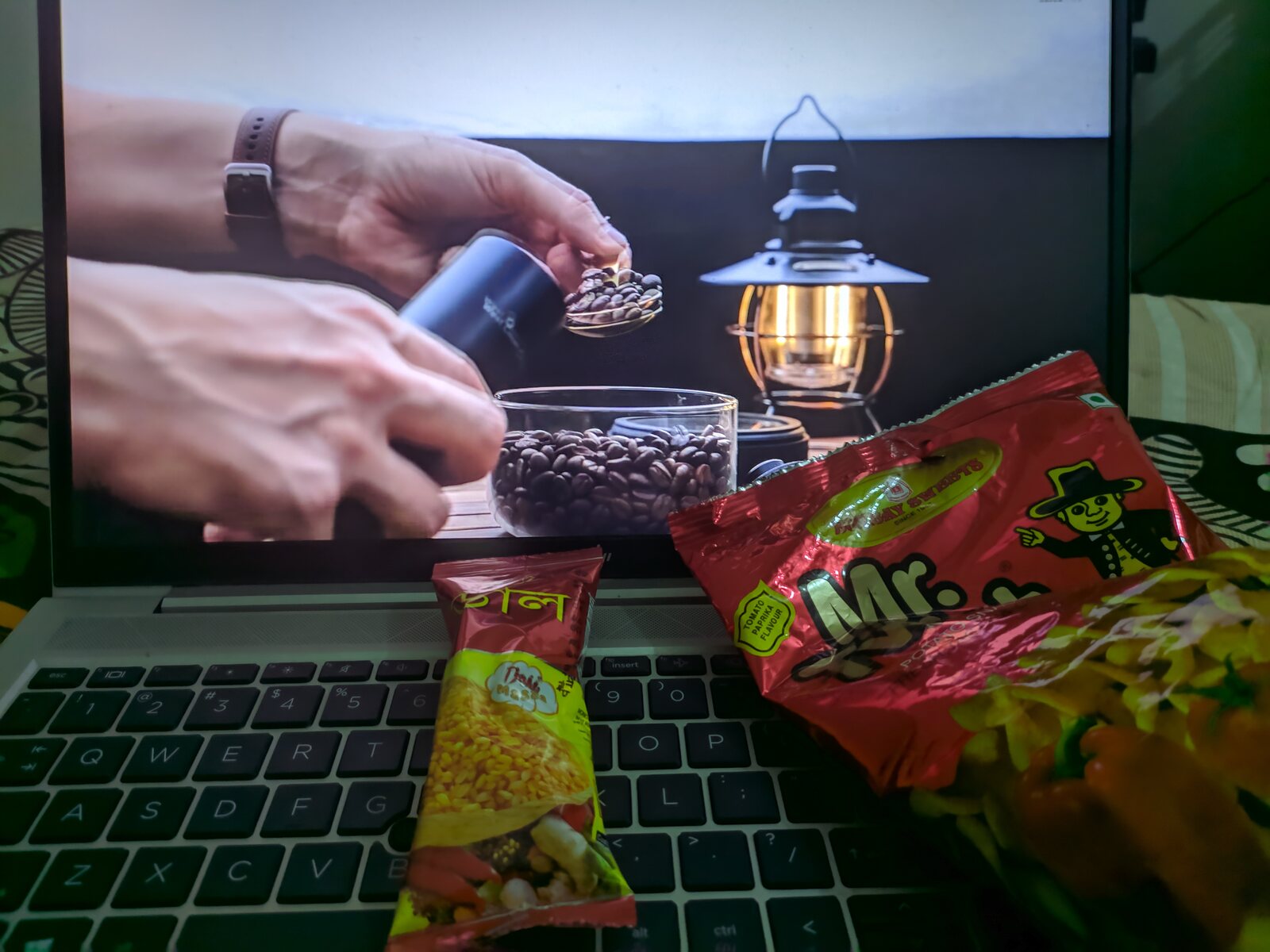 A laptop playing an off-road driving video beside a plate of food.